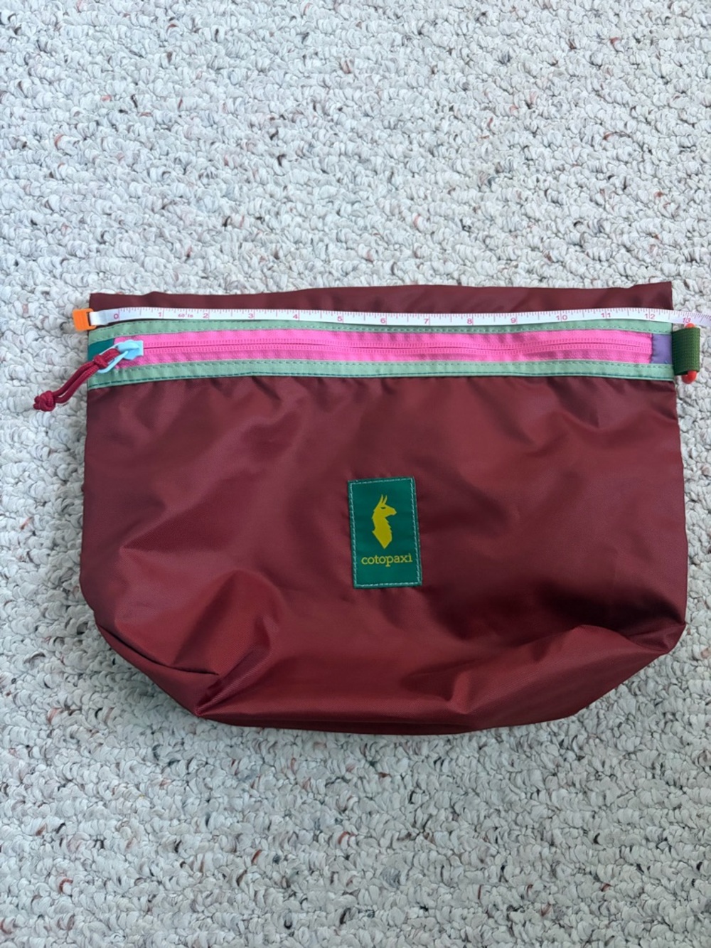 cotopaxi maroon toiletry pouch with pink and mint trim